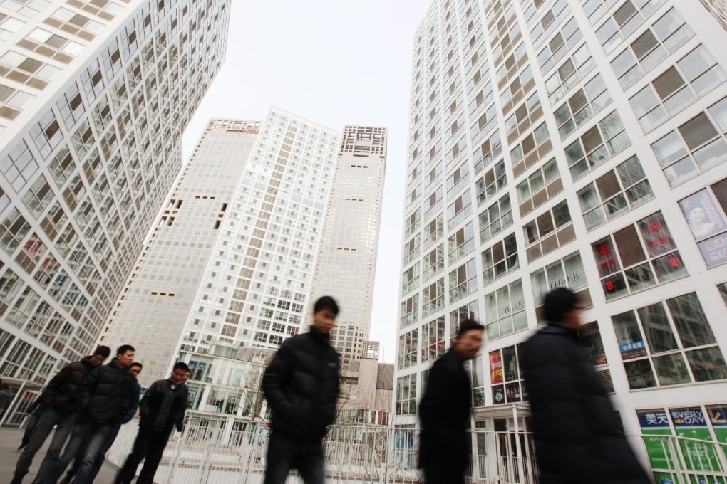 People walk through a building complex in Beijing. Photo: EPA