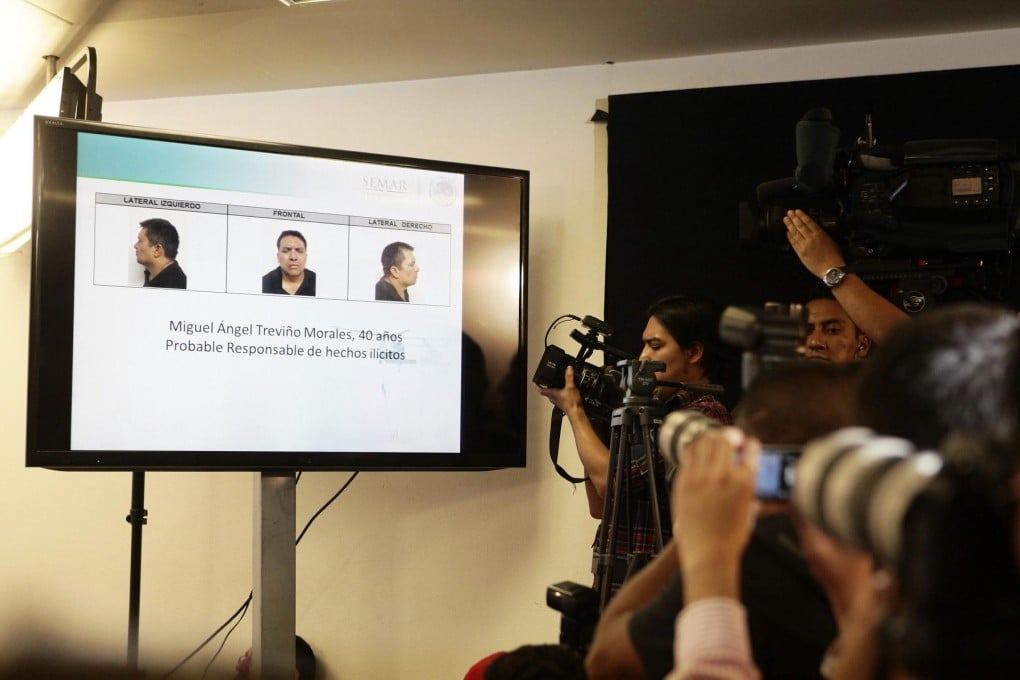 Cameramen record the image of Zetas chief Miguel Angel Trevino at a Mexico City press conference announcing his capture.Photo: EPA