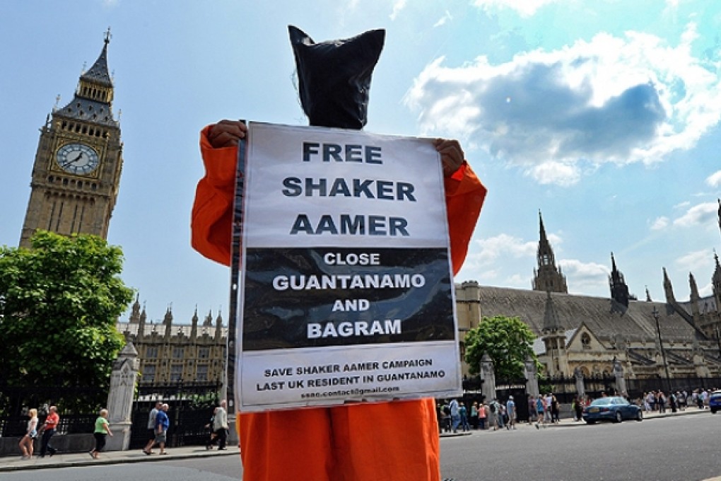 Campaigners wearing Guantanamo Bay detainee jump suits protest outside the parliament in London. Photo: EPA