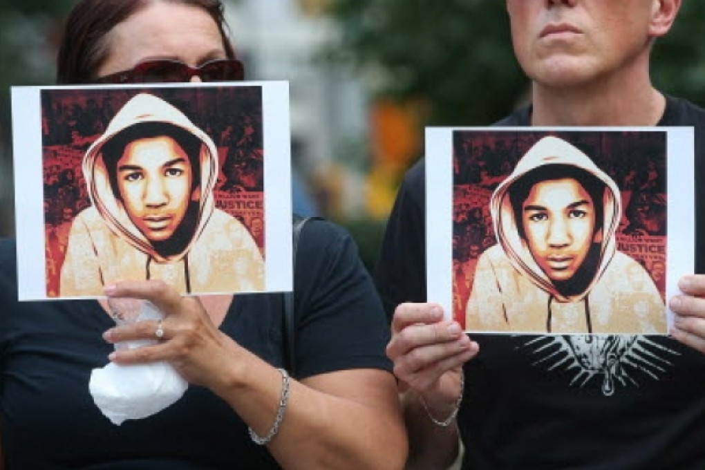 People hold photos of Trayvon Martin at a rally honoring him. Photo: AFP