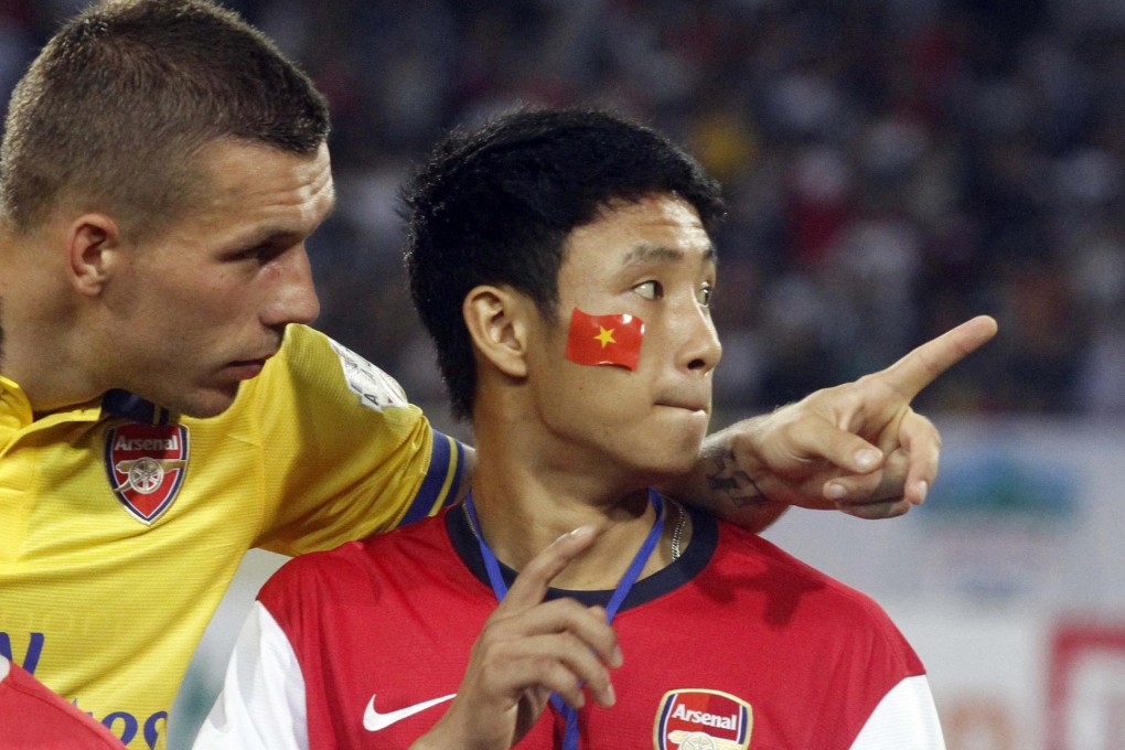 Arsenal's Lukas Podolski with Vu Xuan Tien. Photo: Reuters
