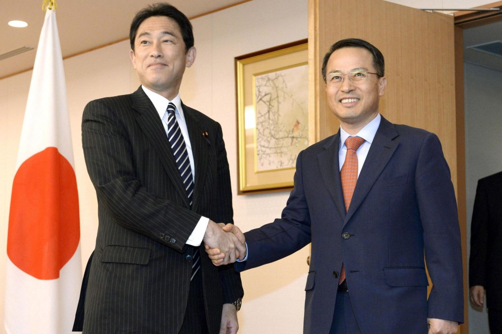 Kishida (left) shakes hands with Kim in Tokyo.Photo: AP