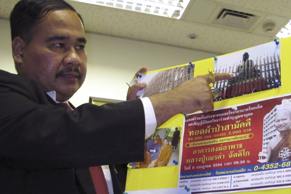 Songkran Artchariyasarp, a lawyer and Buddhist activist, shows a picture of a Buddha statue that is part of an alleged embezzlement by former Buddhist monk Wirapol Sukphol in Bangkok. Photo: AP