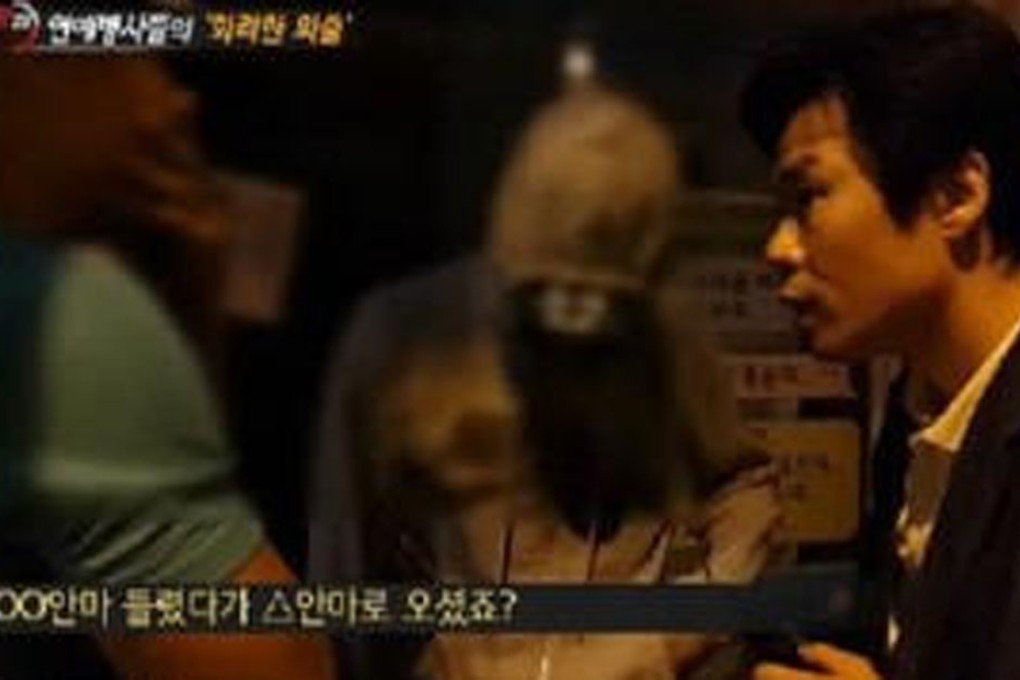 A reporter confronts singers Seven and Sangchu in a scene from the SBS video of eight celebrity soldiers caught visiting bars and clubs.