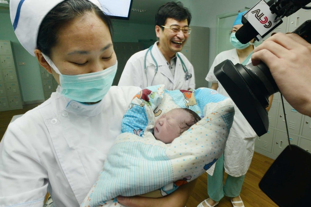 A nurse hugs the baby girl of Qiu, the first pregnant woman in the world infected with H7N9 bird flu, in the No.1 People's Hospital of Zhenjiang, east China's Jiangsu Province. Photo: Xinhua