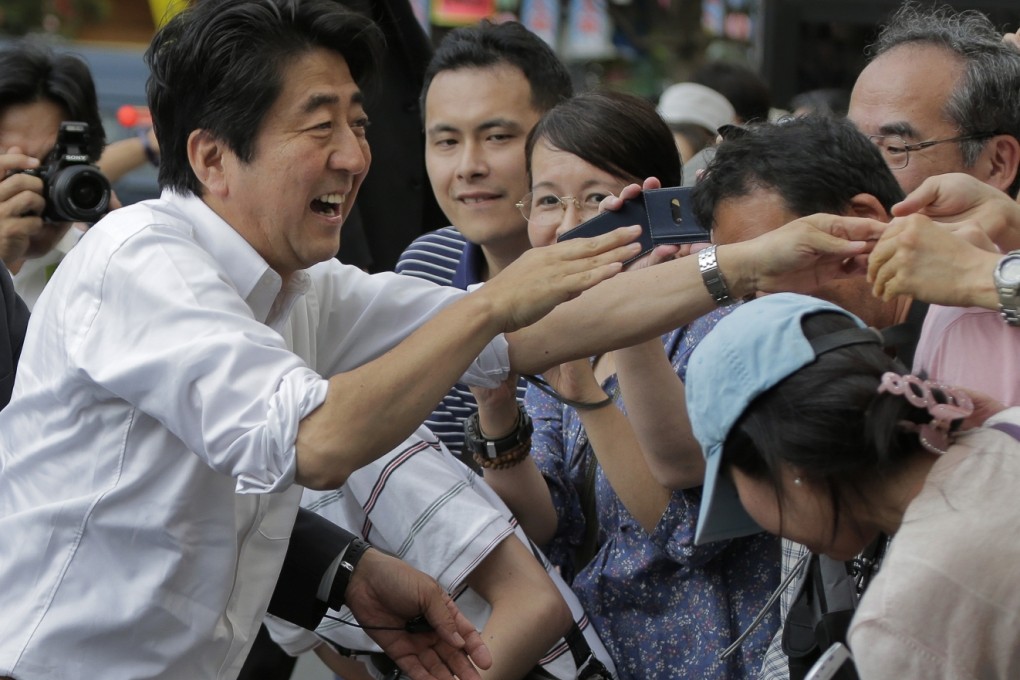Japanese Prime Minister and the ruling Liberal Democratic Party's leader Shinzo Abe, left, greets audience during the last day of parliamentary upper house election campaign in Tokyo on Saturday. Photo: AP