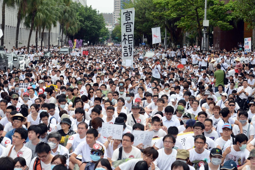 Protesters sit down during an anti-military rally outside the Defence Ministry in Taipei. Photo: AP