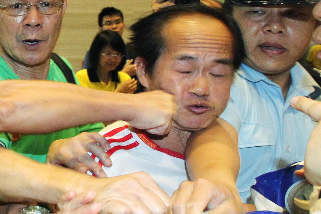 A member of Caring Hong Kong Power is punched in the face after the democracy event turned ugly yesterday. Photo: SCMP