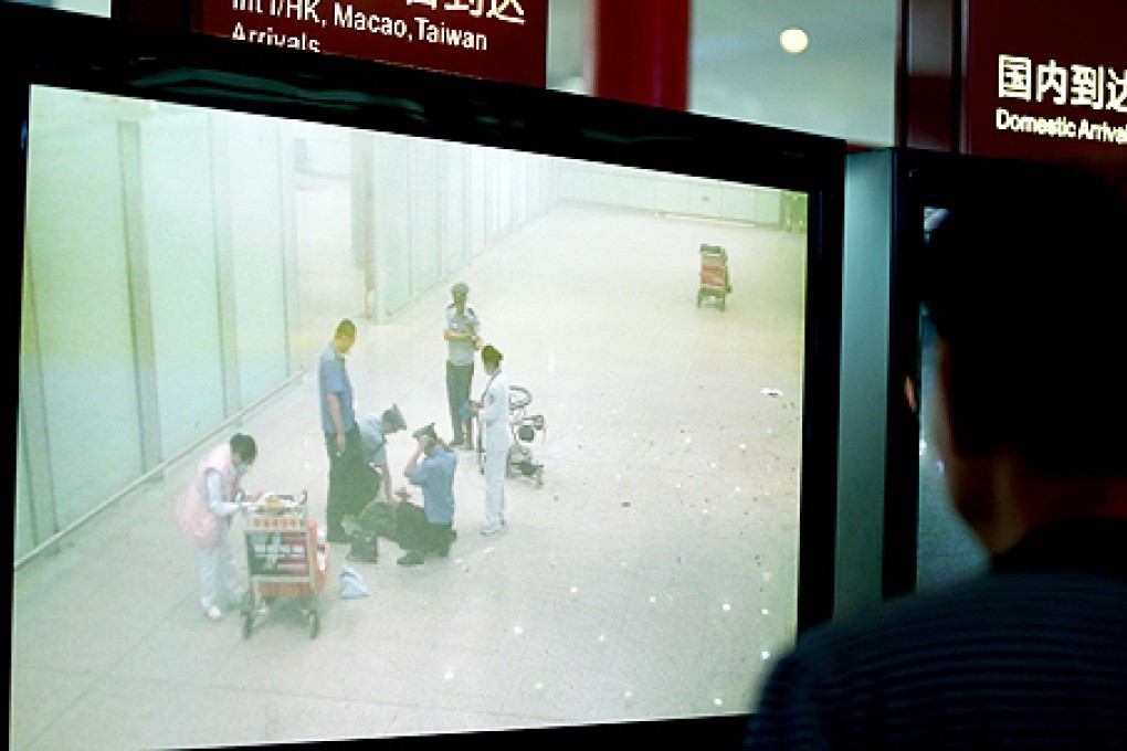 A man watches the closed-circuit television system broadcasting an explosion in T3 terminal at the Beijing Capital International Airport on Saturday. Photo: Xinhua