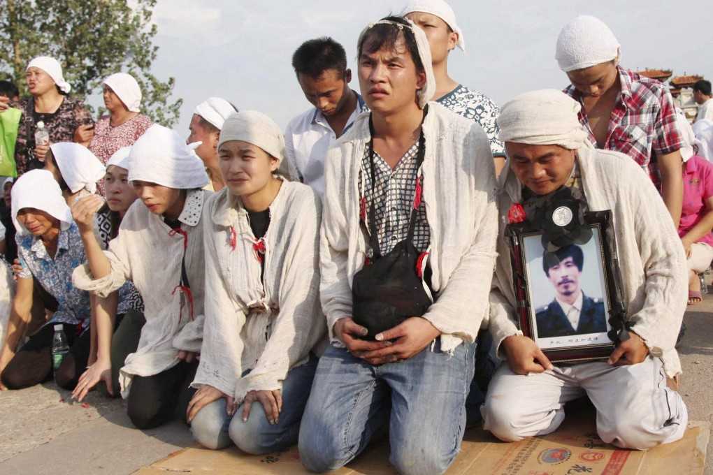 Relatives grieve as they hold a picture of Deng. Photo: Reuters