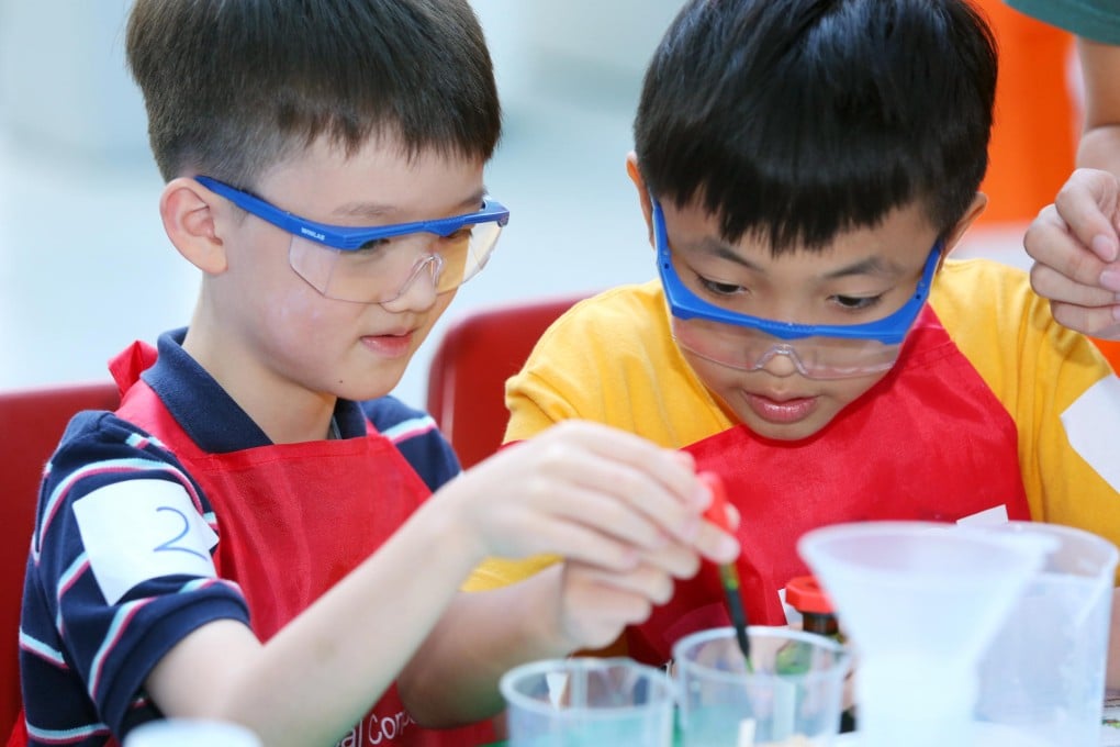 Bill Koo (left) and Herman Chan performing water purification experiments in the Kids Lab.
