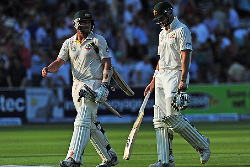 James Pattinson and Ryan Harris (right) of Australia leave the field after their defeat by England on Sunday. Photo: AFP