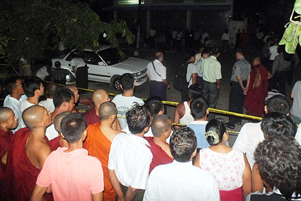 Buddhist monks and residents watch police examining a car after an explosion in Mandalay, central Myanmar. Photo: AP