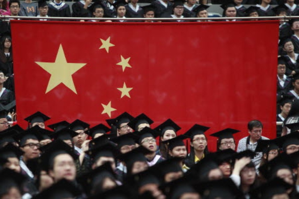 Graduates stand next to the Chinese flag during a graduation ceremony at Fudan University in Shanghai June 28, 2013. Photo: Reuters