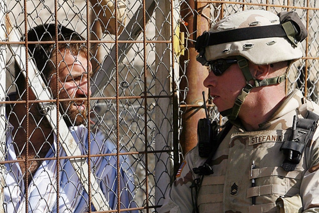 A member of US military personnel talks to a detainee waiting to be released at the Abu Ghraib prison in Baghdad. Photo: AP