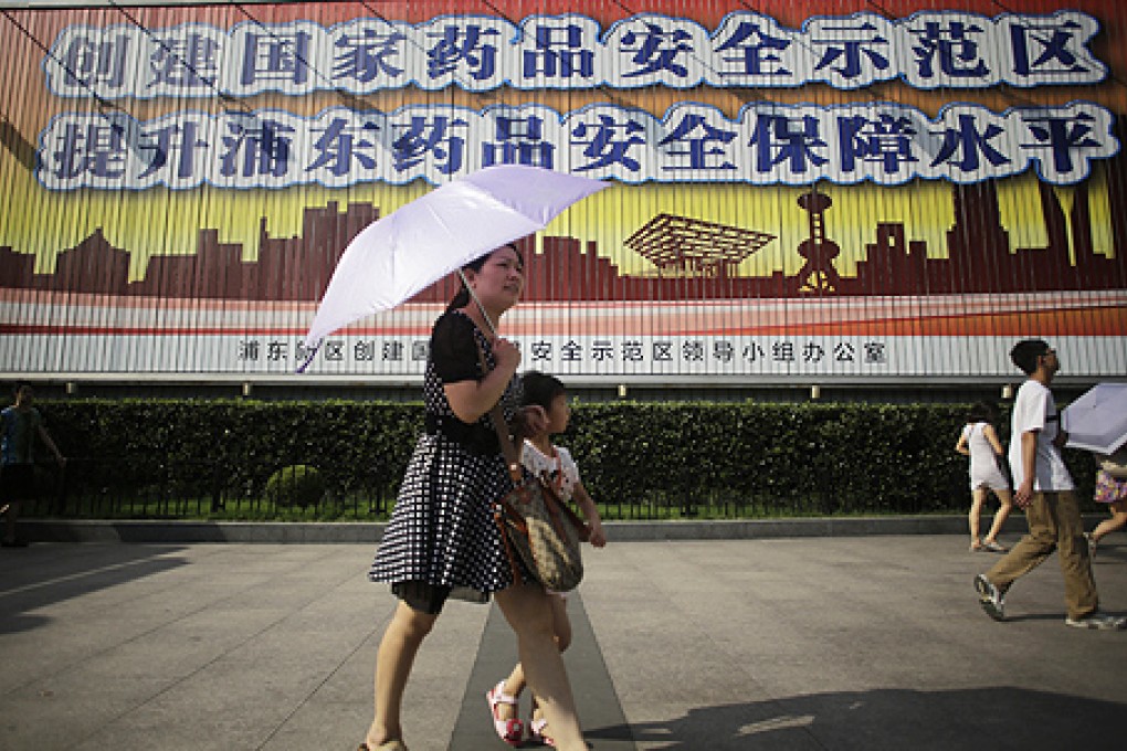 People walk in front of a public service advertisement for drug safety in Shanghai. A US citizen has been detained in China, on Monday, in an ongoing probe into corruption by multinational pharmaceutical companies. Photo: AP
