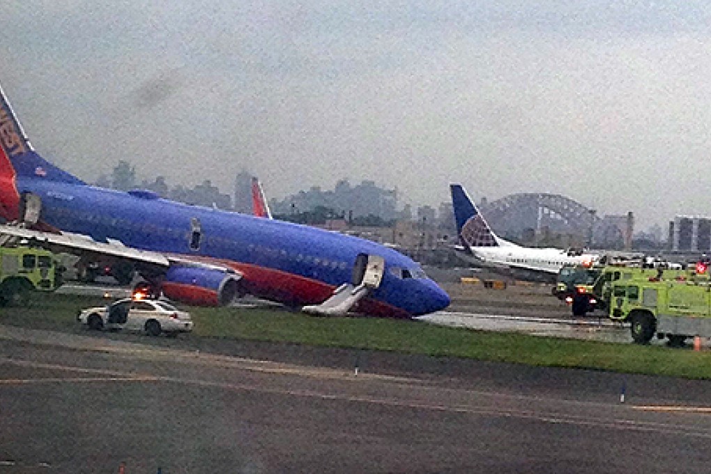A Southwest Airlines plane whose nose gear collapsed as it touched down on the runway is surrounded by emergency vehicles at LaGuardia Airport. Photo: AP