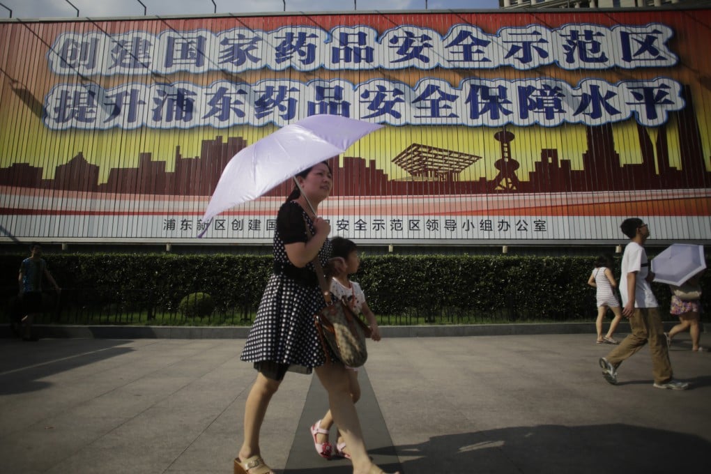 Tourists walk in front of a public service advertisement for drug safety in Shanghai. Photo: AP