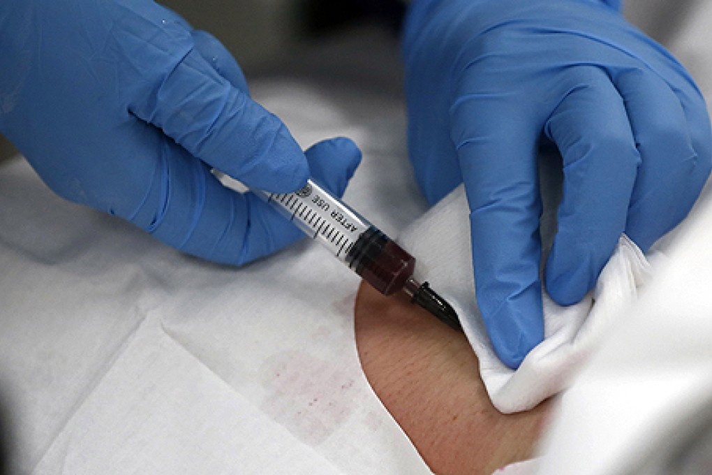 A doctor draws blood from a patient at a hospital in Shanghai. Corruption at hospitals stems largely from doctors’ low base salaries Photo: Reuters