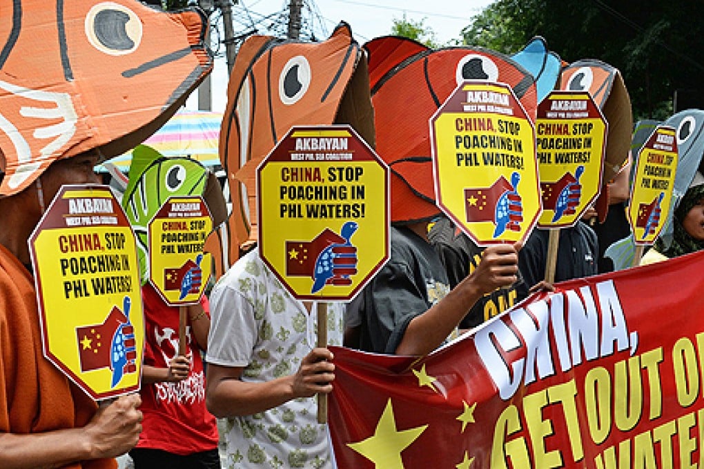 Protesters in cut-out fish costumes carry anti-China placards during a protest in front of the building housing the Chinese consular office in the financial district of Manila on Wednesday. Photo: AFP