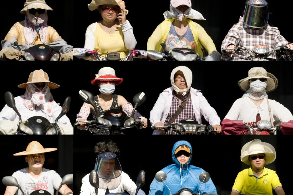 Cyclists in Hangzhou have been forced to come up with various protective measures for shade. Temperatures surpassed 40 degrees for the second consecutive day yesterday. Photo: Imaginechina.