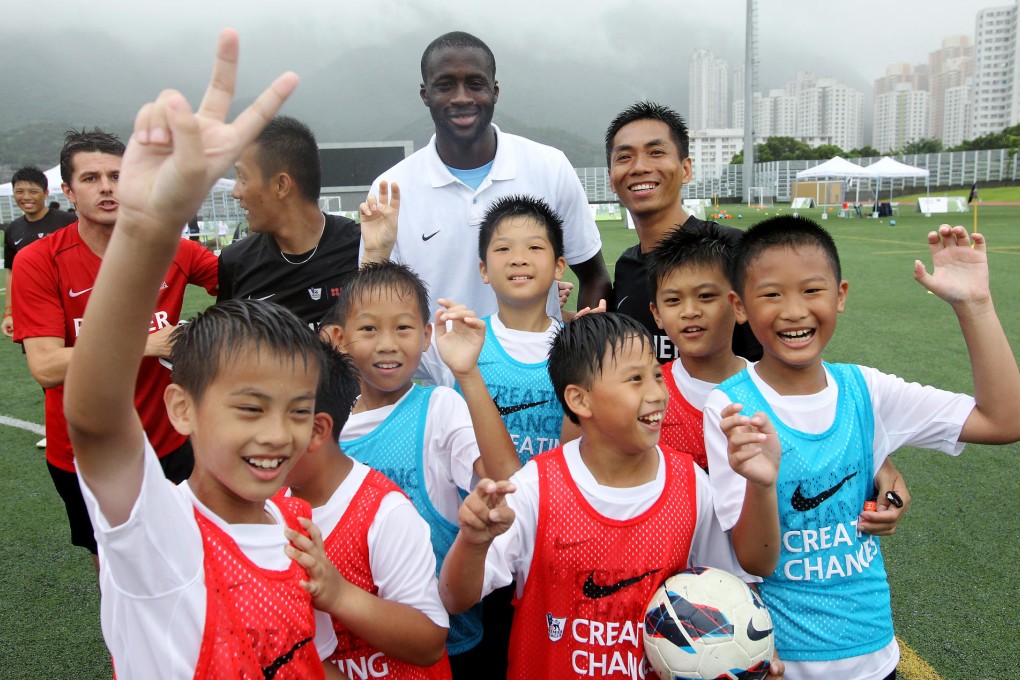 Manchester City ace Yaya Toure gets together with young players at a coaching clinic in Diamond Hill yesterday. Photo: Edward Wong