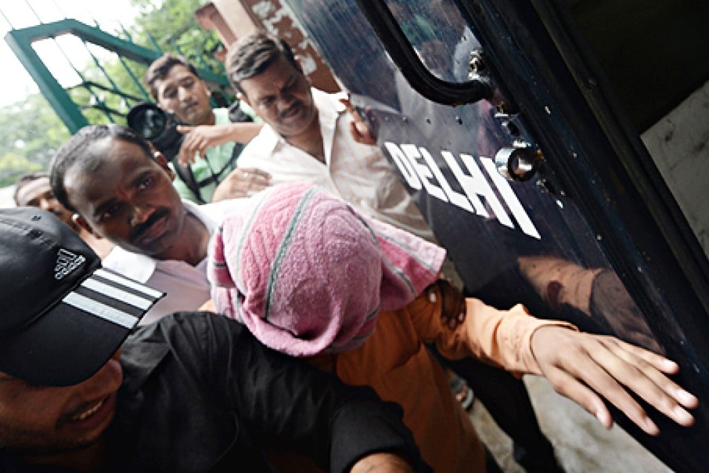 Indian policemen escort the juvenile accused (centre, in pink towel) in the December 2012 gang-rape of a student, into a police truck outside the juvenile court in New Delhi on Thursday. Photo: AFP