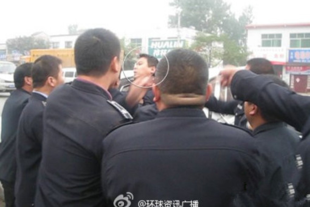 Bystanders documented the Qinghai policeman's beating by chengguan on Tuesday. Screenshot from Sina Weibo.