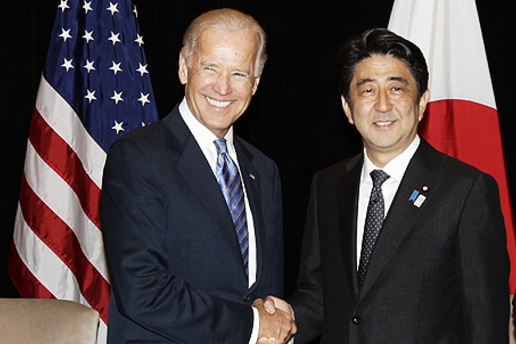 US Vice President Joe Biden (left) and Japan's Prime Minister Shinzo Abe smile at photographers as they shake hands during their bilateral meeting in Singapore on Friday. Photo: AP