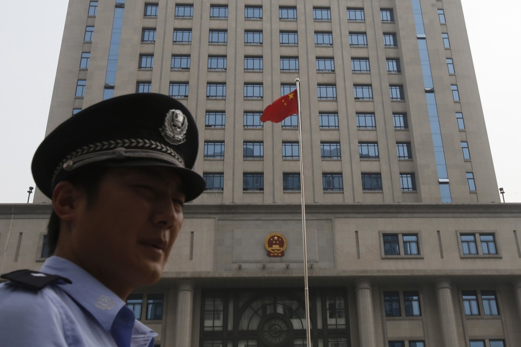 A policeman stand guards in front of the Jinan Municipality People's Intermediate Courthouse building. Photo: Reuters
