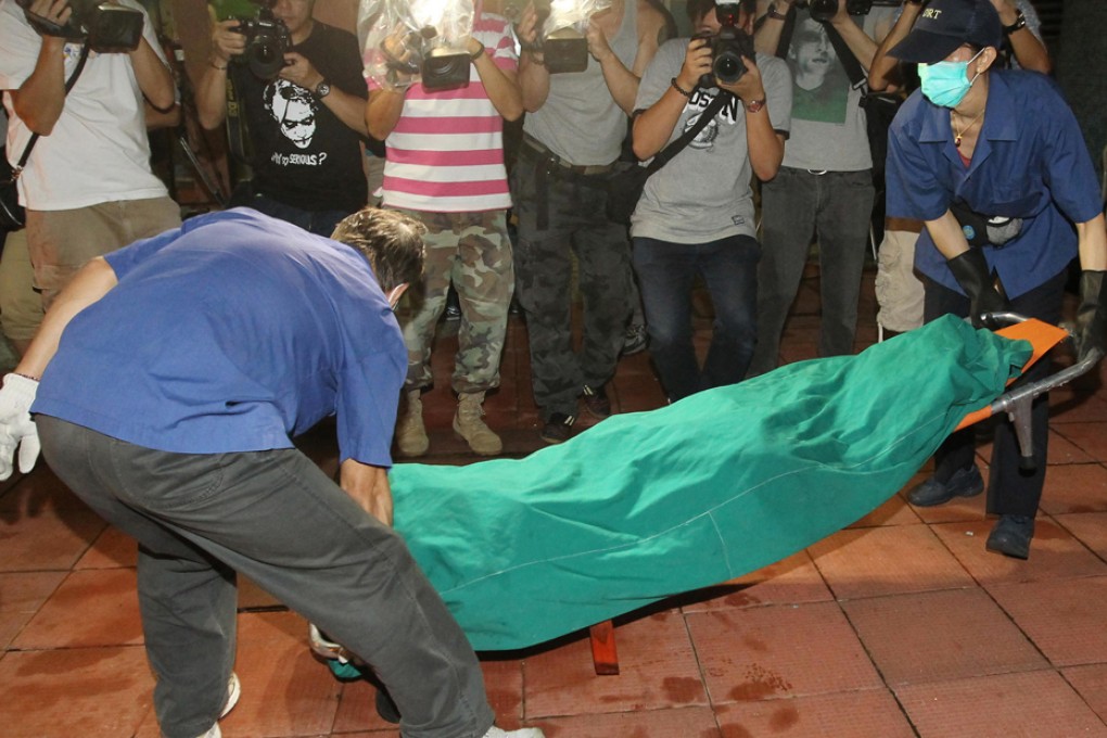 The bodies of the woman and her two children are removed from the flat last night. Photo: Edward Wong