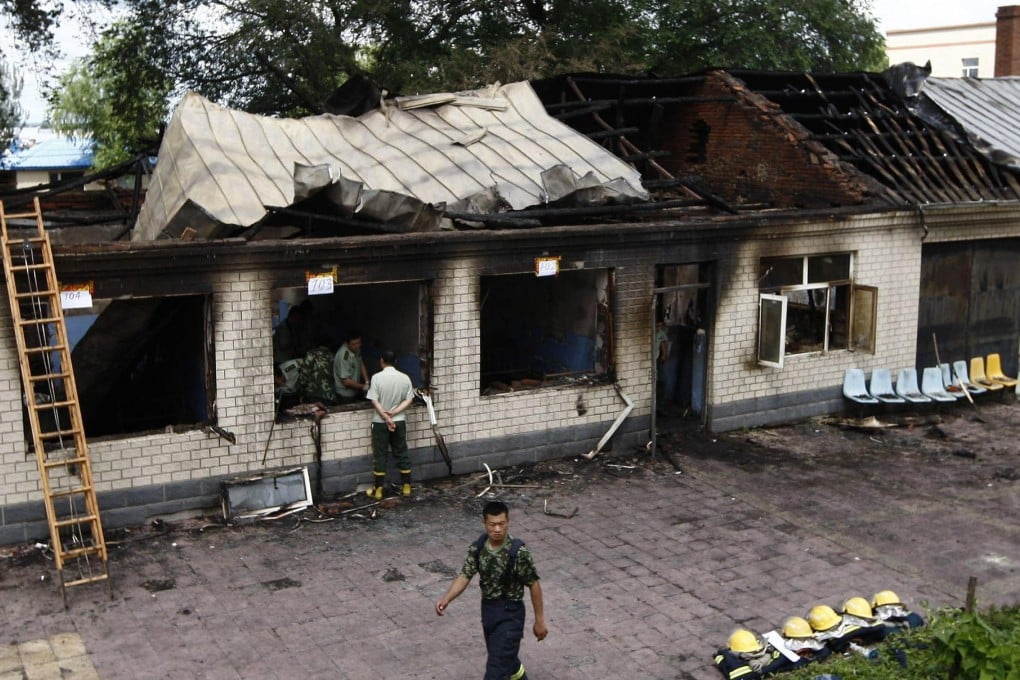 Firefighters inspect the burnt-out nursing home after the deadly blaze started by a male patient early yesterday that took more than an hour to extinguish. Photo: AFP