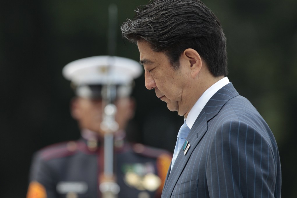 Japanese Prime Minister Shinzo Abe bows beside a Filipino honor guard during wreath laying ceremonies at the monument of Philippine National Hero Jose Rizal on Saturday. Photo: AP