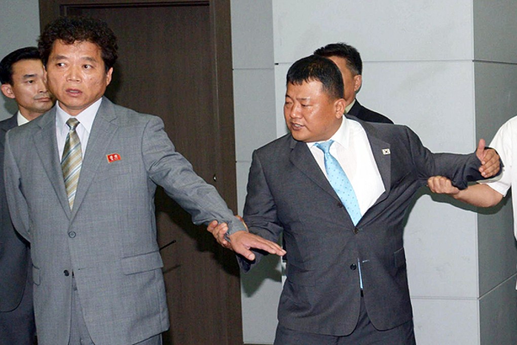 A South Korean official (centre) tangles with representatives of the North during the scuffle at the Kaesong industrial estate. Photo: AFP