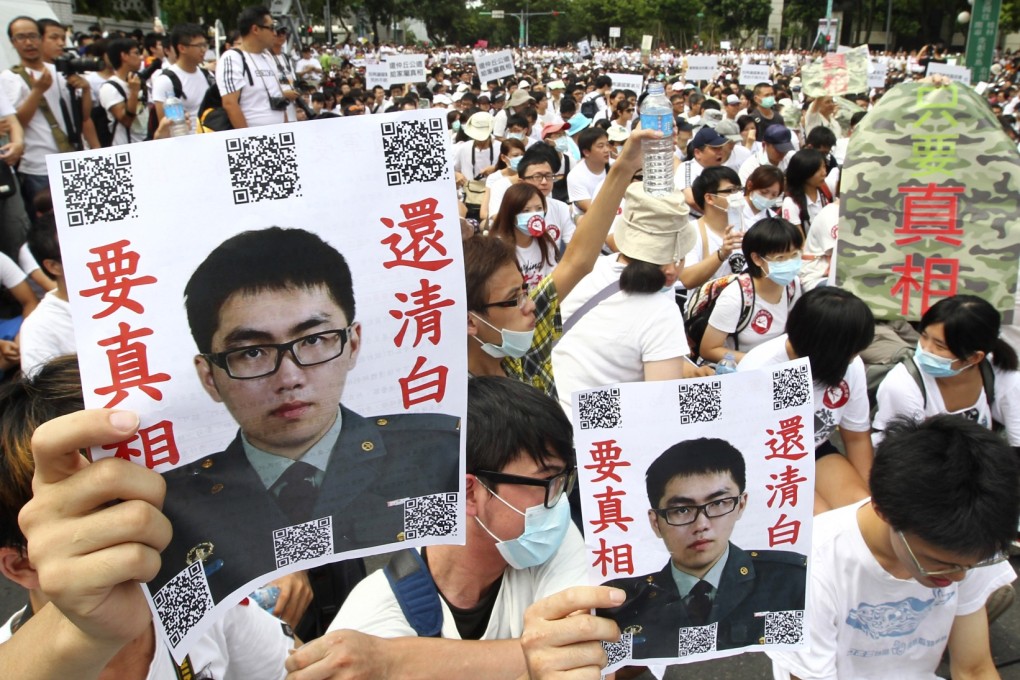 Taiwanese protesters hold posters that read "Give the truth" next to portraits of Taiwan soldier Hung Chung-chiu who died in early July after being forced to perform a vigorous regime of calisthenics in sweltering heat on a base in suburban Taipei. Photo: AP