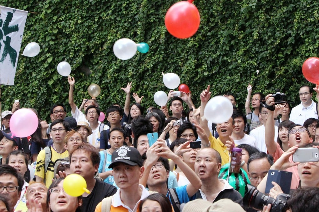 Protesters release balloons during their protest march yesterday. "Po", part of Paul Chan's name, sounds like "ball" in Cantonese, so some released balloons in a symbolic gesture. Photo: David Wong