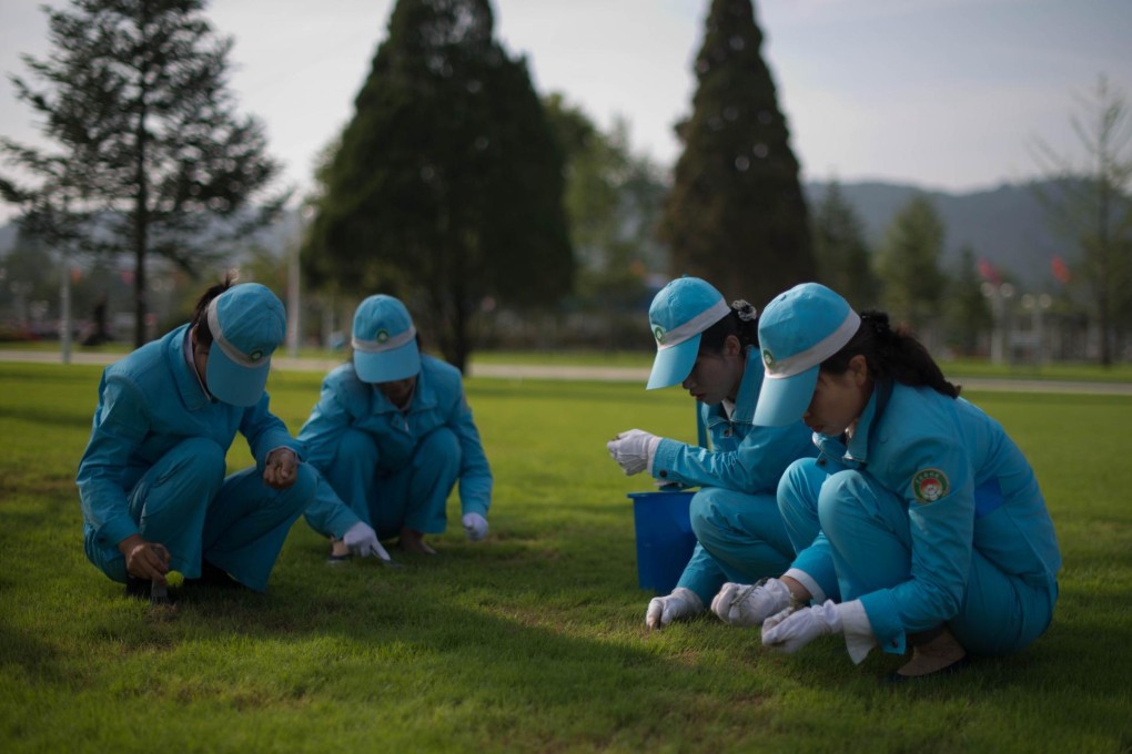 Workers tend to the Kumsusan Palace grass in Pyongyang. Photo: AFP