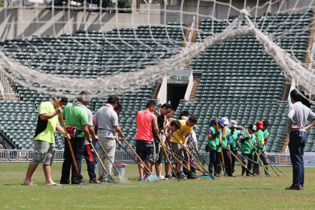 Workers check the pitch at Hong Kong Stadium on Sunday. Photo: Felix Wong
