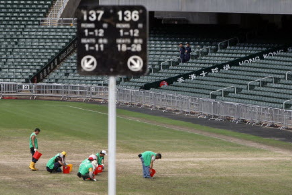 Workers perform maintenance work on the turf of Hong Kong Stadium in Causeway Bay before the match between Kitchee and Manchester United. Photo: David Wong
