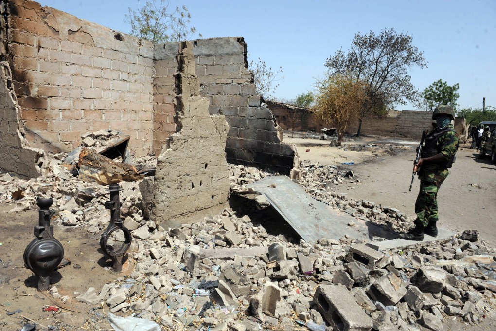 A soldier stands beside a house burnt during a clash between Islamist insurgents and soldiers in April 2013. Photo: AFP