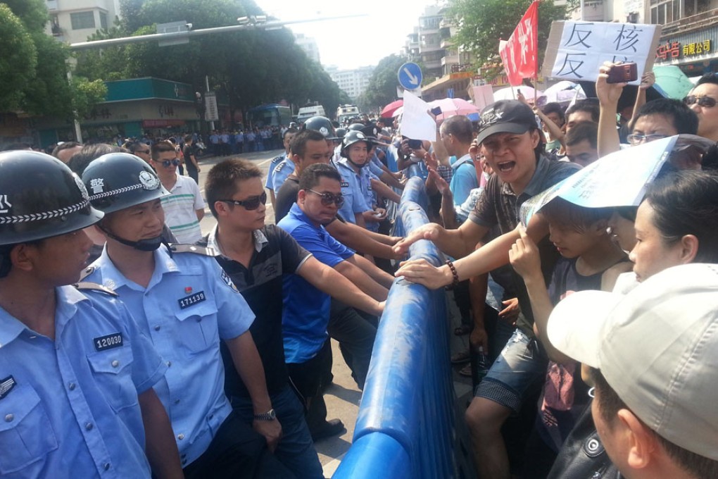 Police standing across demonstrators during a protest against plans for a uranium processing plant in Jiangmen. Photo: Reuters