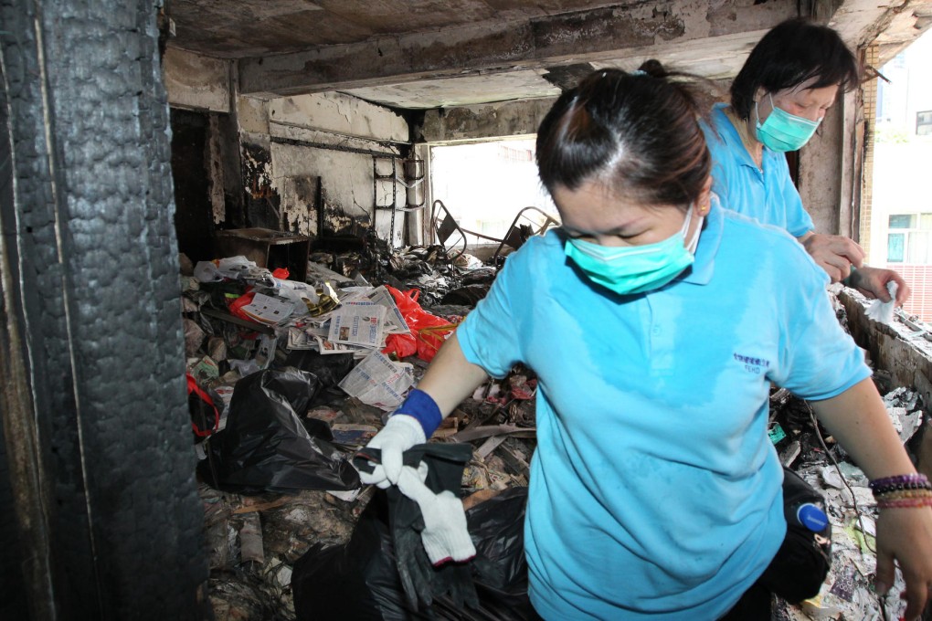 Government workers wear face masks as they remove piles of garbage, including old newspapers, from Tam Man-ip's top-floor flat in Mee Lun Street, Central. Photo: Nora Tam