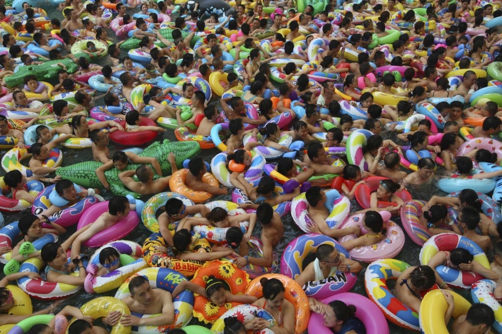Visitors trying to escape the summer heat swim in an artificial wave pool at a tourist resort in Daying county, Suining. Photo: Reuters