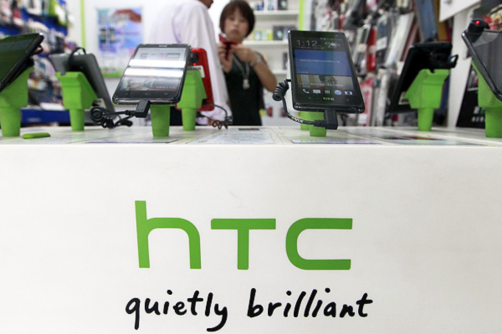 Customers look at HTC smartphones in a mobile phone shop in Taipei. Photo: Reuters