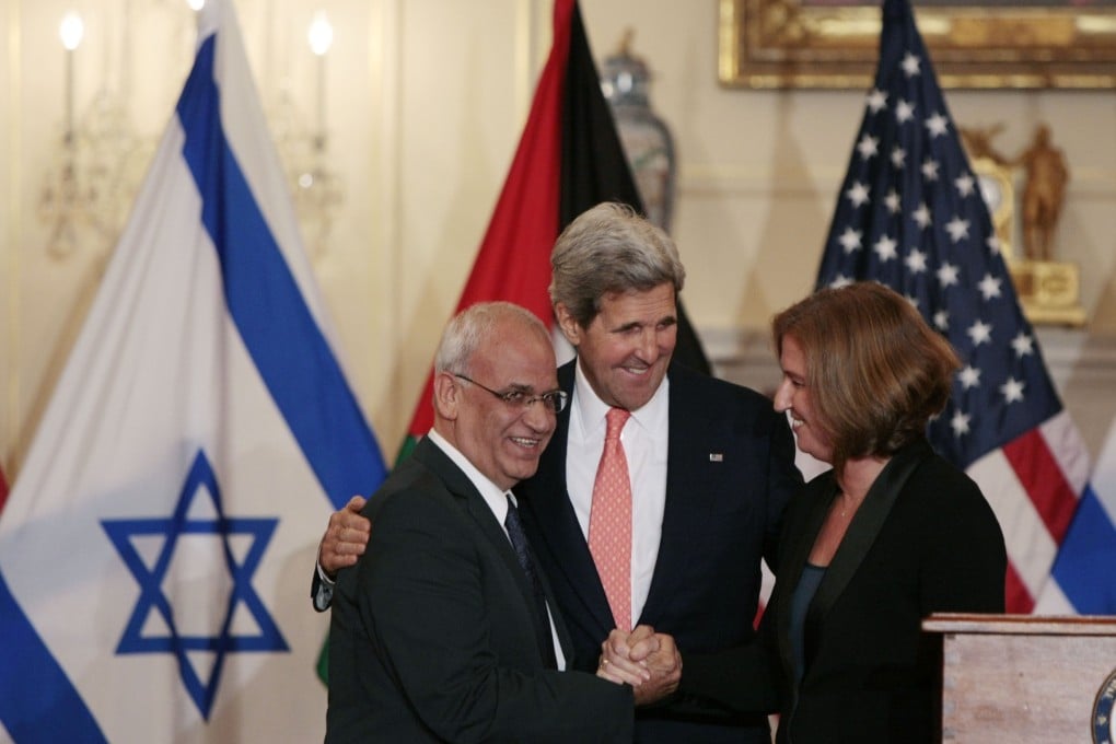 Israeli Justice Minister Tzipi Livni (right) and Palestinian chief negotiator Saeb Erekat (left) shake hands after the press conference with US Secretary of State John Kerry at the conclusion of two-day initial talks. Photo: Xinhua