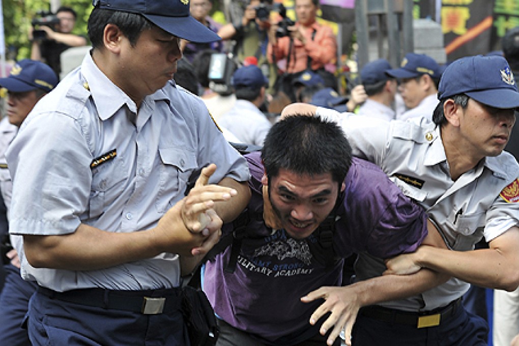 Police officers drag a protester away in front of the Legislative Yuan in Taipei. Photo: Reuters