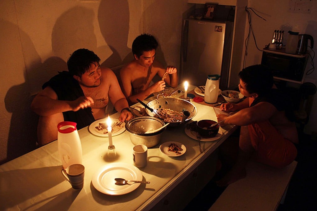 A family uses candles for light as they eat in Legazpi City, Albay province, southeast of Manila. Photo: AFP