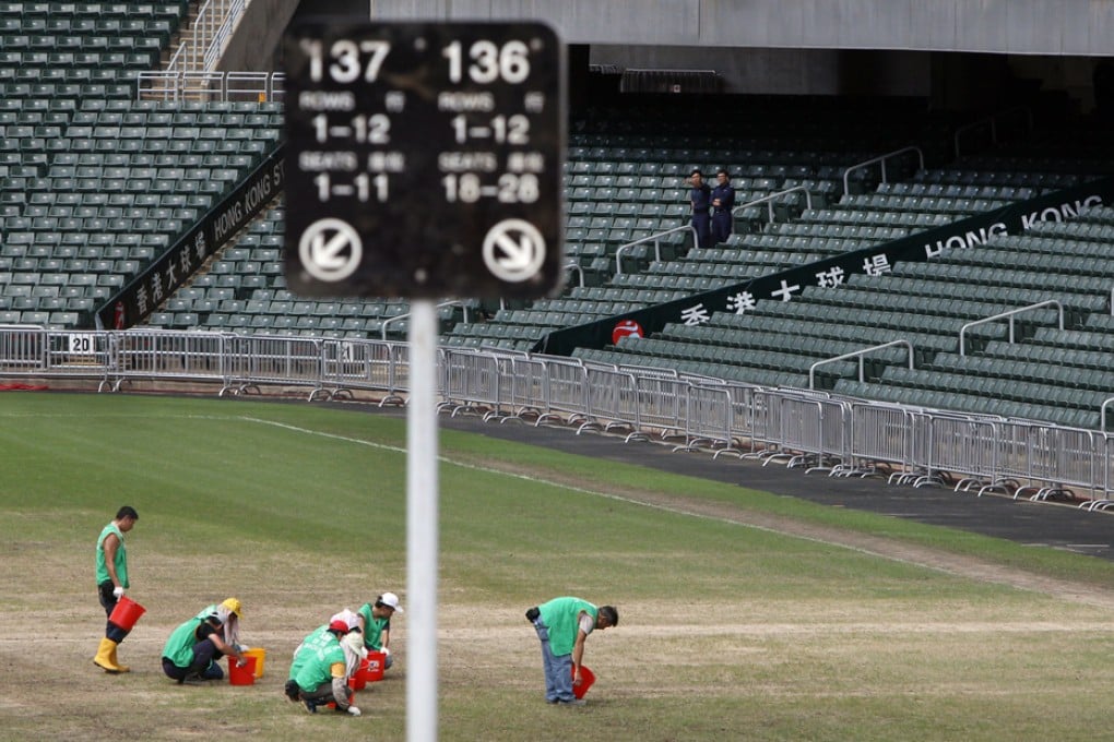 Workers try to repair the pitch. Photo: David Wong