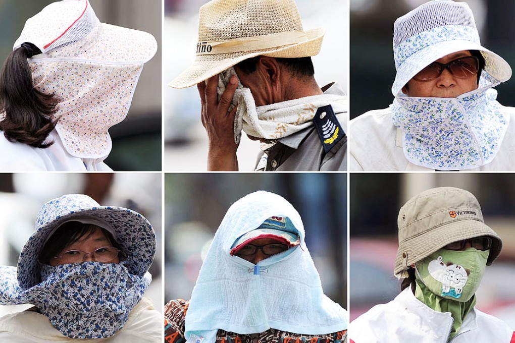 Citizens shield themselves from the sun in Hangzhou, capital of east China's Zhejiang province. Photo: Xinhua