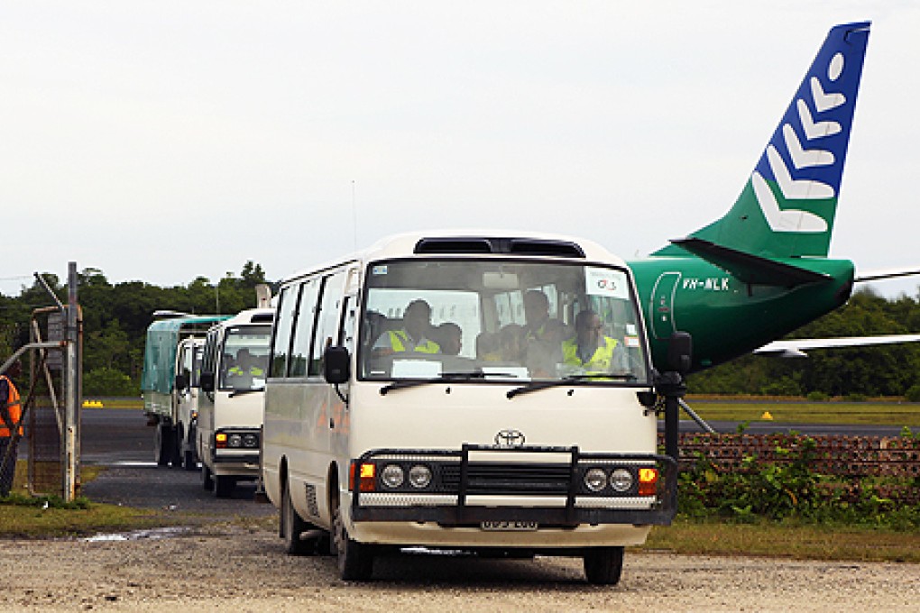 The first group of 40 asylum-seekers arrive in mini-buses shortly after landing on Manus Island, Papua New Guinea, formally bringing into effect the Regional Settlement Arrangement on Thursday. Photo: AFP